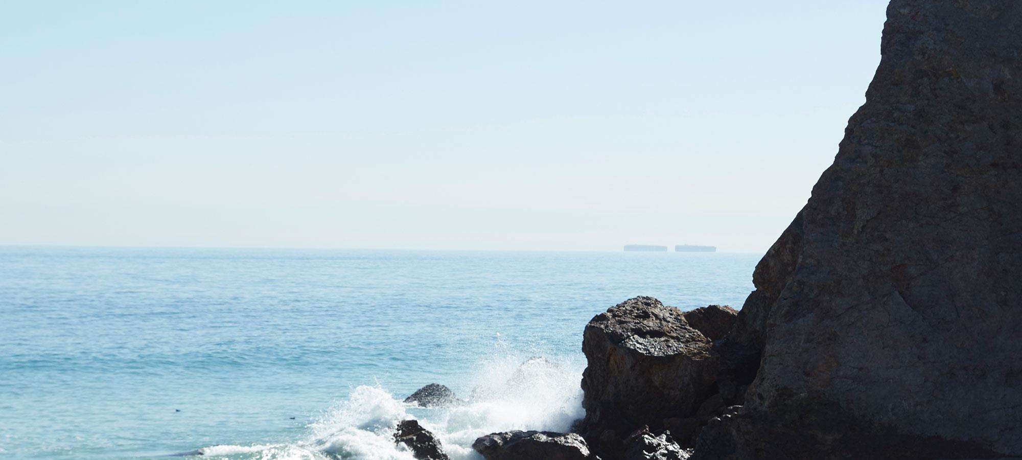 Acufene spiaggia onde si infrangono sulla roccia